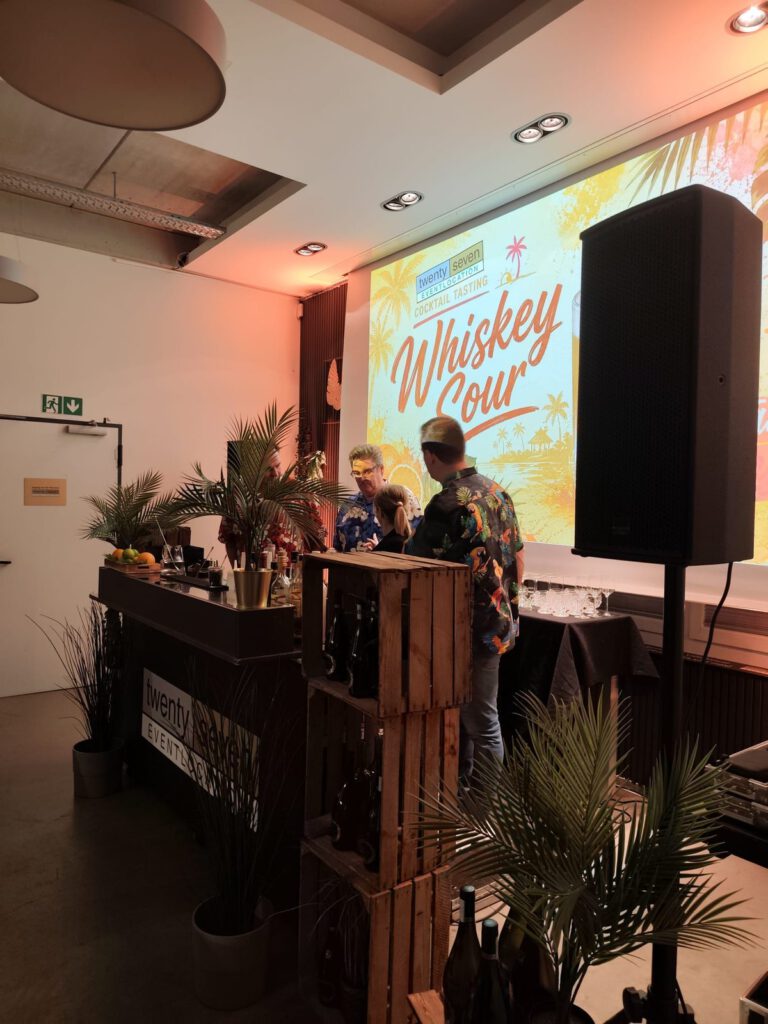 Die mit Palmen dekorierte Cocktailbar vor der Leinwand