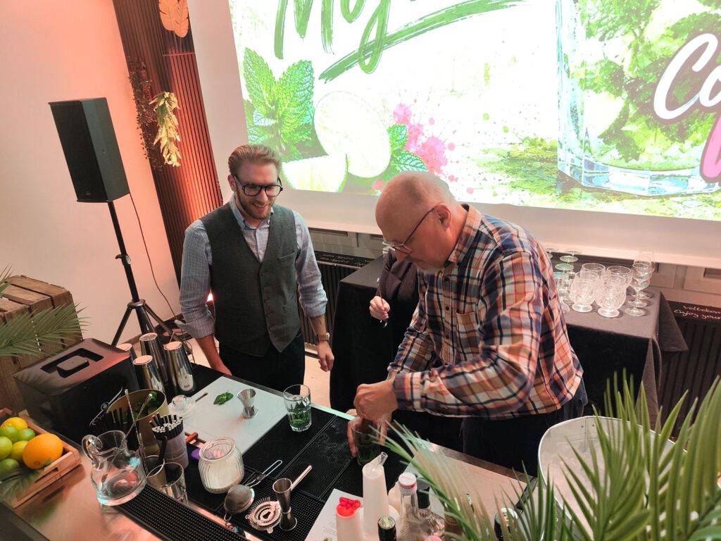 Ein Gast mixt unter Anleitung einen Mojito an der Cocktailbar